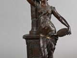 bronze statue of a woman with a basket on her head