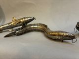 three fish shaped metal objects on a white surface