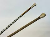 pair of antique canes with silver and wood handles on a white background