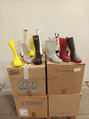 several pairs of rain boots are stacked on top of a cardboard box
