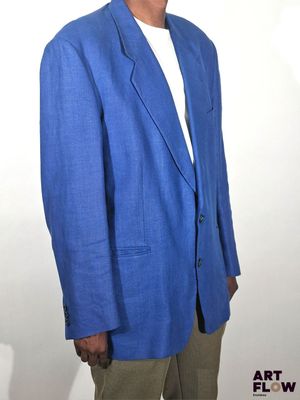 un homme vêtu d'une veste bleue et d'un pantalon kaki qui pose pour une photo