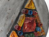 a picture of a metal triangle with colorful stones in it