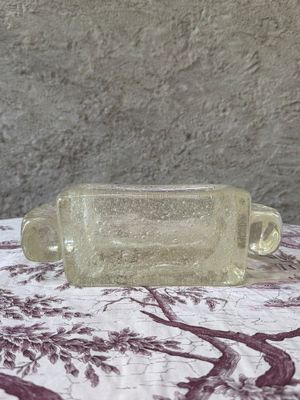 a glass bottle sitting on a table with a red and white table cloth