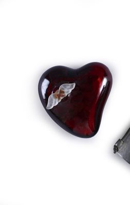 a heart shaped glass object with a butterfly on it
