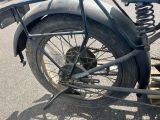 une moto noire garée sur le bord de la route