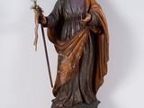 wooden statue of jesus holding a staff with a flower in his hand