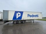 un semi-remorque blanc arborant un logo bleu et blanc, garé sur un parking