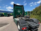 a green semi truck that is parked on the side of the road