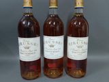 trois bouteilles de vin posées l'une à côté de l'autre sur une table