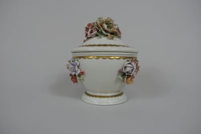un bol blanc orné de fleurs, posé sur une table