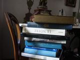 une pile de livres posée sur une chaise en bois