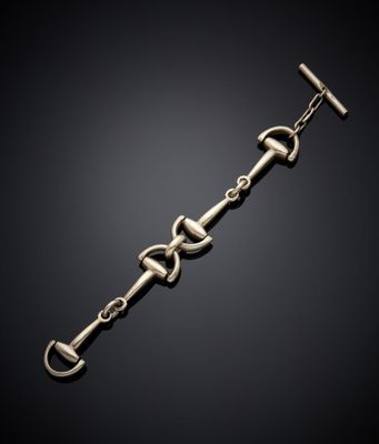 un gros plan d'un bracelet en métal muni d'un fermoir, sur fond noir