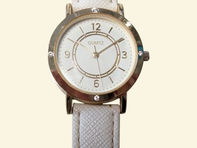 a close up of a wrist watch on a white strap