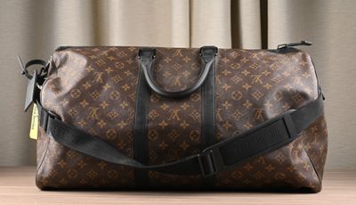 louis vuittou bag sitting on a table in front of a curtain