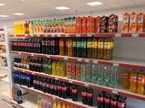 many different types of drinks on the shelves in the store