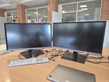 two computer monitors and a laptop on a desk