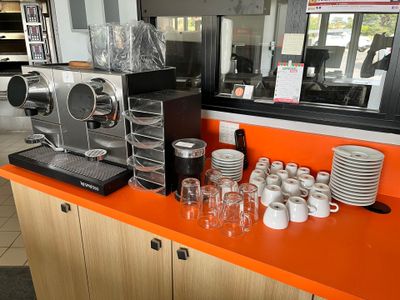 une machine à café et des tasses posées sur le comptoir d'un café