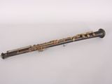 an old black and gold flute on a white surface