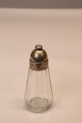 une petite salière et poivrière en verre posées sur une table