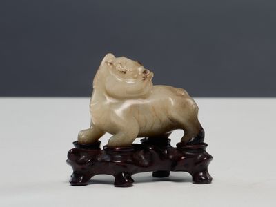 Figurine chinoise en ivoire sculpté représentant un lion, posée sur un socle