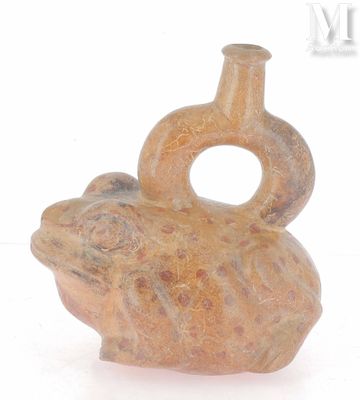 un petit vase orné d'une grenouille, posé sur une surface blanche