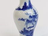 a blue and white vase sitting on a white surface