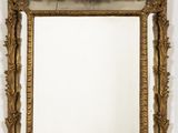 an image of a gold framed mirror hanging on a wall
