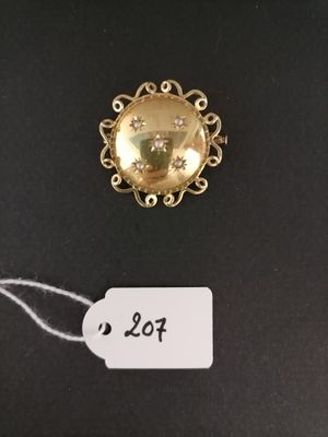 a close up of a gold brooch with a price tag on it