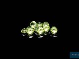 a close up of a bunch of green gems on a black surface
