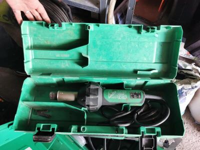 a green tool box with tools in it on the floor