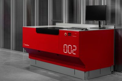 une horloge rouge posée sur un bureau dans une pièce