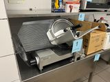 an image of a meat slicer sitting on a table in a kitchen