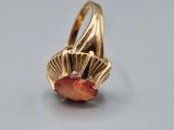 an image of a gold ring with a red stone in the center