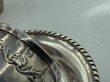 a silver plate with a spoon and a spoon rest on top of it