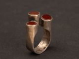 bague en argent ornée de deux pierres rouges sur un fond noir