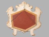 a red and white octagonal mirror on a gray wall