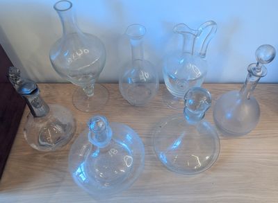 beaucoup de bouteilles en verre vides posées sur une table en bois