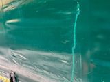 painting on the side of a green truck with a yellow stripe