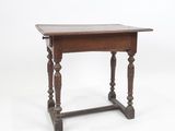 une vieille table en bois aux pieds tournés, sur fond blanc