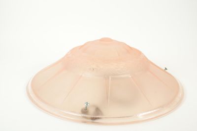 un dôme en plastique posé sur une surface blanche, surmonté d'une lampe