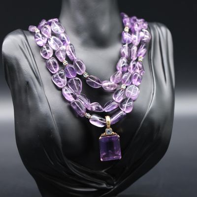 a close up of a mannequin with a purple necklace on it