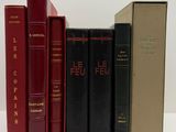trois livres sont alignés les uns à côté des autres sur une surface blanche