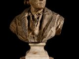 marble bust of a man in a suit and tie on a pedestal