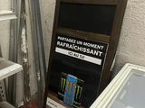 a refrigerator and a cooler in a room with a sign on the wall