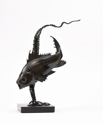 sculpture représentant un poisson posé sur un socle, avec un serpent sur le dos
