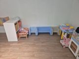 une pièce avec une table, des chaises et des jouets par terre