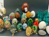 de nombreux œufs et vases de différentes couleurs posés sur une table