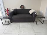 a black couch and two tables in a living room