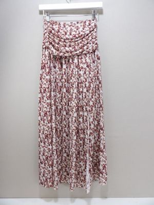 a red and white floral print skirt hanging on a hanger