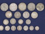 an assortment of silver coins on a blue cloth